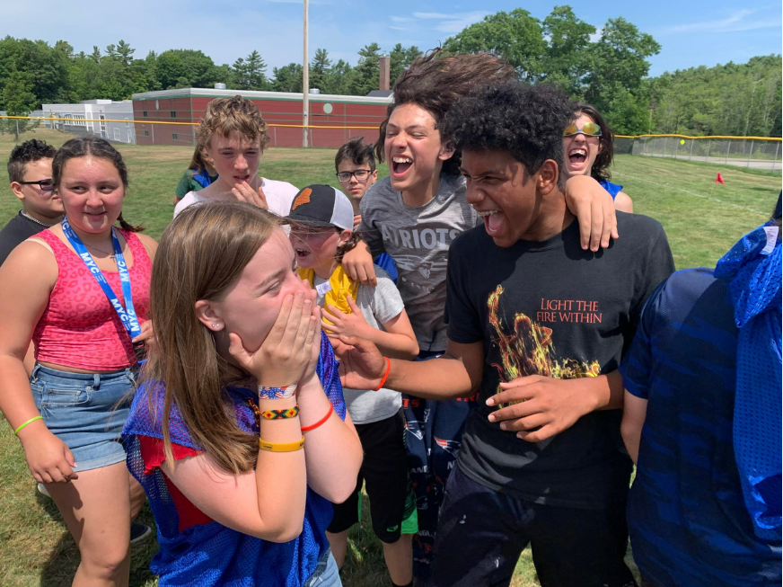 Placeholder: a group of MYC youth celebrating together outdoors on a playing field.